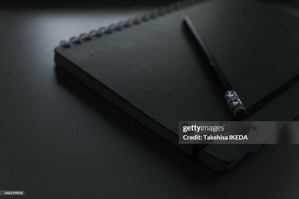 Pencil and Black Notebook
