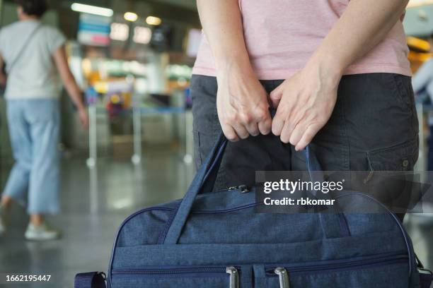 carry on luggage - female hands holding a bag at the station - gym bag stock pictures, royalty-free photos & images