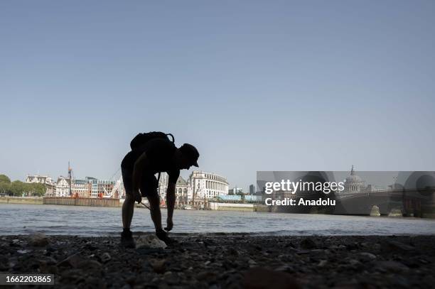 Man searches for an antique from the Thames River bed after the water retreats in London, United Kingdom on September 11, 2023. For centuries, people...