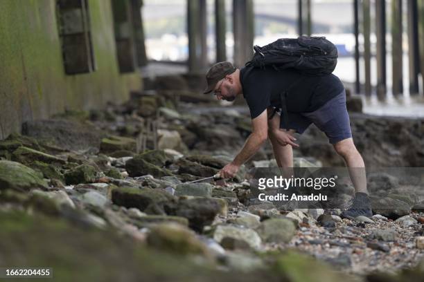 Man searches for an antique from the Thames River bed after the water retreats in London, United Kingdom on September 11, 2023. For centuries, people...