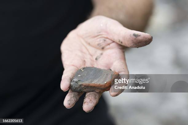 Man shows an object he unearthed from the Thames River bed after the water retreats in London, United Kingdom on September 11, 2023. For centuries,...