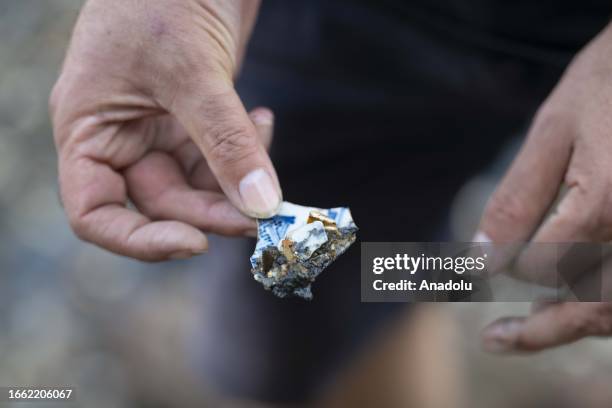 Man shows an object he unearthed from the Thames River bed after the water retreats in London, United Kingdom on September 11, 2023. For centuries,...