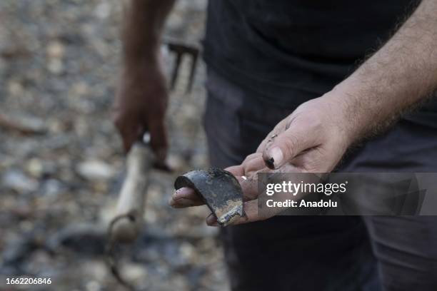 Man shows an object he unearthed from the Thames River bed after the water retreats in London, United Kingdom on September 11, 2023. For centuries,...