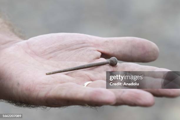 Man shows an object he unearthed from the Thames River bed after the water retreats in London, United Kingdom on September 11, 2023. For centuries,...