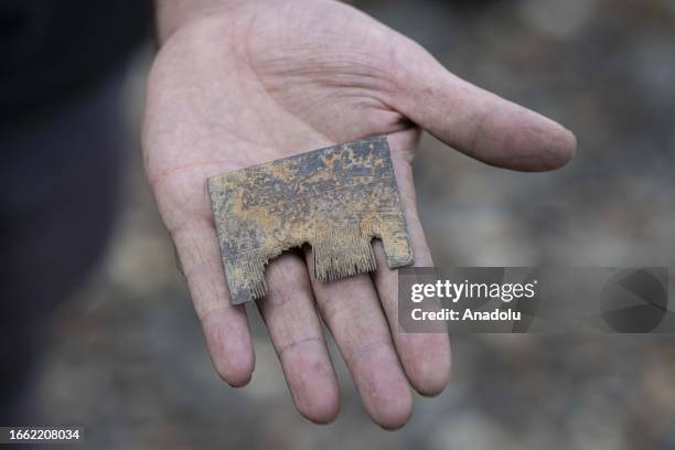 Man shows an object he unearthed from the Thames River bed after the water retreats in London, United Kingdom on September 11, 2023. For centuries,...