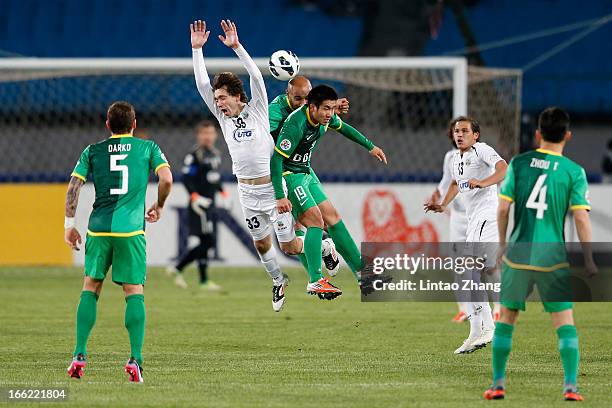 Oleg Zoteev of Bunyodkor competes for an aerial ball with Wang Xiaolong and Frederic Kanoute of Beijing Guoan during the AFC Champions League Group...