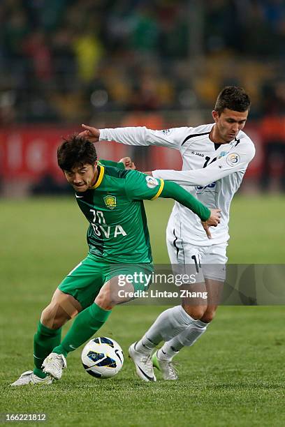 Alibobo Rakhmatullaev of Bunyodkor challenges Zhang Xinxin of Beijing Guoan during the AFC Champions League Group match between Bunyodkor and Beijing...