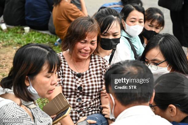 Relative cries while waiting outside a funeral house during the identification of victims of the major fire at an apartment block in Hanoi on...