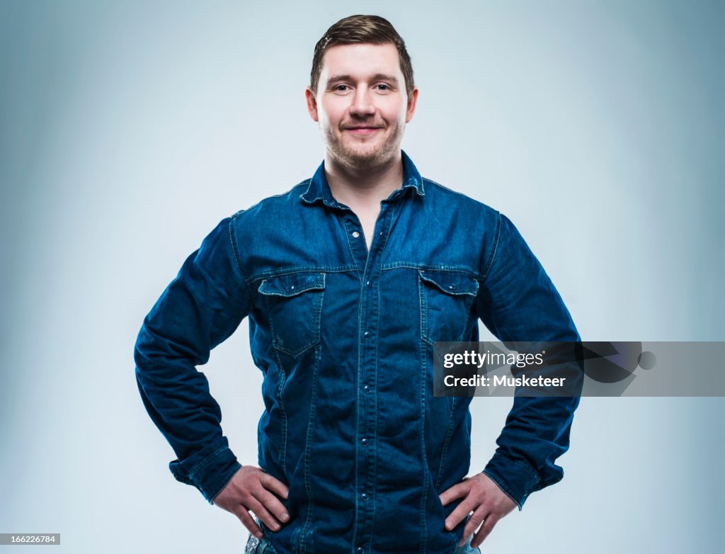 Confident young man with hands on his hips