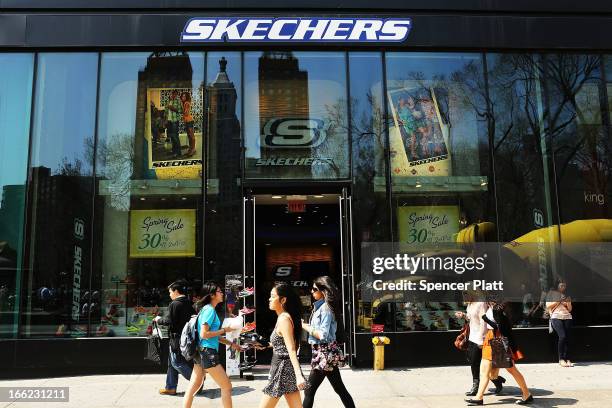 People walk by a Skechers store on April 10, 2013 in New York City. The California-based footwear maker Skechers and nutritional products group...