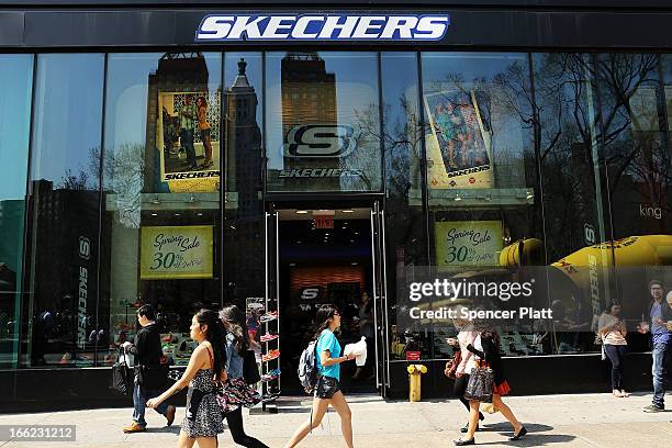 People walk by a Skechers store on April 10, 2013 in New York City. The California-based footwear maker Skechers and nutritional products group...