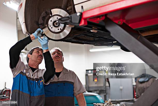 mechanics check calibration on brakes - repair garage stock pictures, royalty-free photos & images