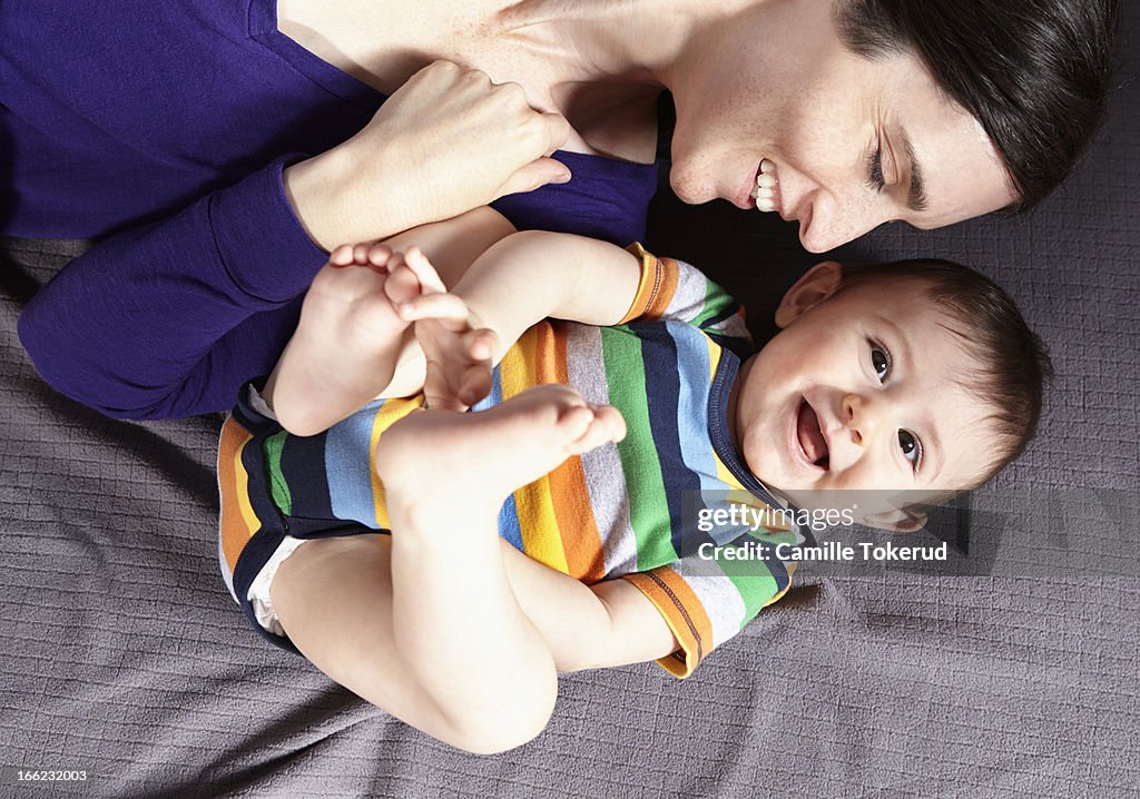 Mother and baby on bed smiling