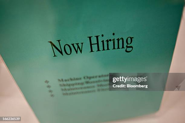 Now Hiring" sign sits on an employer's table during a job fair at Illinois Valley Community College in Oglesby, Illinois, U.S., on Wednesday, April...