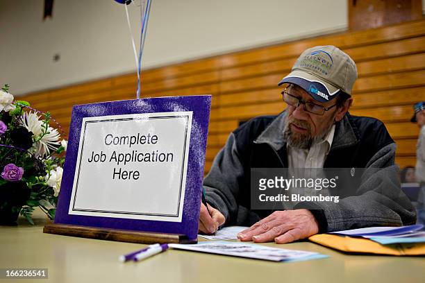 Job seeker Clinton Crouch who said he was laid-off in Sept. 2011, fills out an application for a maintenance job during a job fair at Illinois Valley...