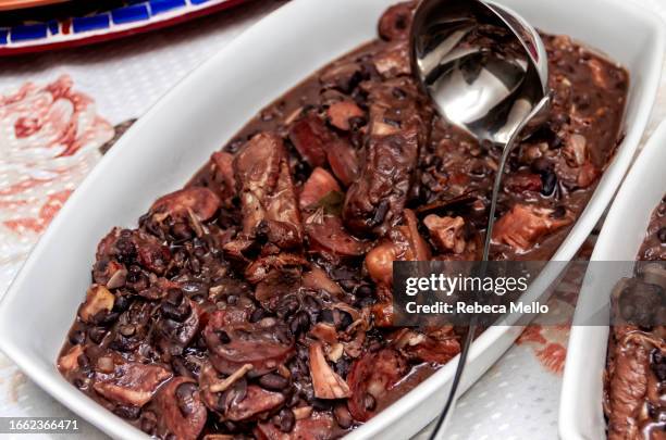 seen from above, a white bowl with stewed meats and black beans, the brazilian feijoada. - feijoada 個照片及圖片檔