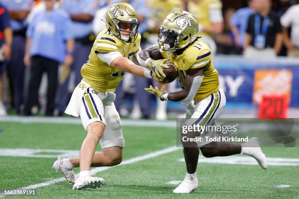 Haynes King hands off to Jamal Haynes of the Georgia Tech Yellow Jackets during the second quarter against the Louisville Cardinals at Mercedes-Benz...