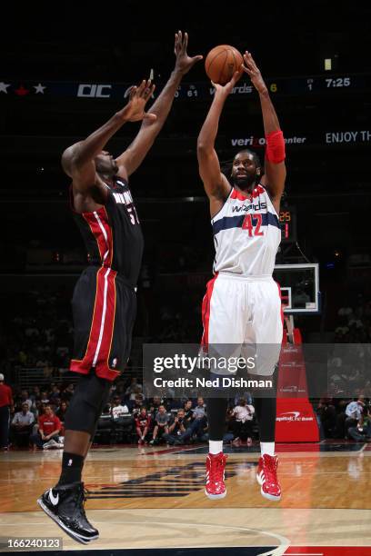 Nene of the Washington Wizards shoots against Joel Anthony of the Miami Heat during the game at the Verizon Center on April 10, 2013 in Washington,...