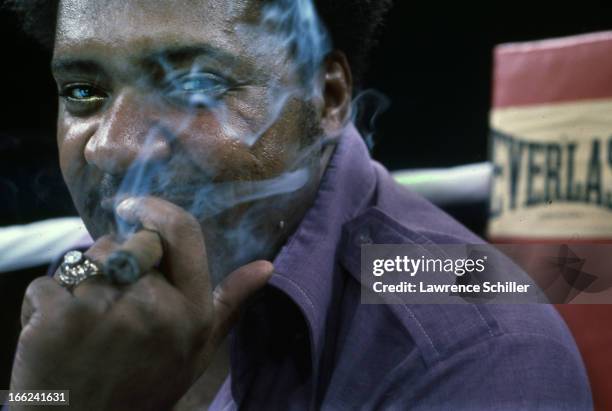 Close-up portrait of American boxing promoter Don King as he smokes a cigar in the ring, the day before 'the Thrilla in Manila,' at the Araneta...