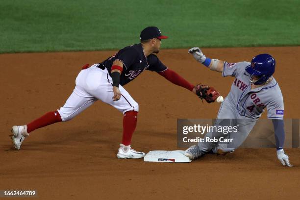 Francisco Alvarez of the New York Mets slides safely into second base for a double as Ildemaro Vargas of the Washington Nationals applies the late...