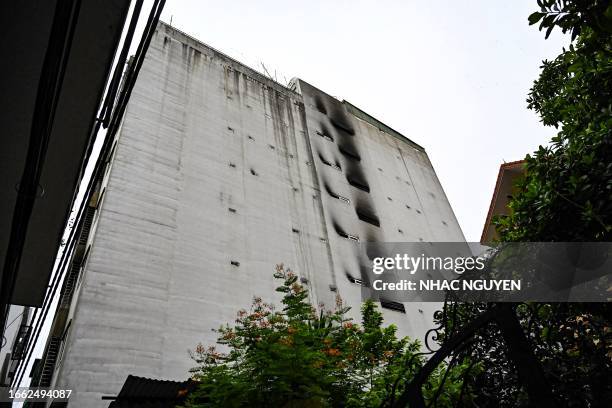 This picture shows the damage on a 10-storey building after a major fire at an apartment block in Hanoi on September 13, 2023. Dozens of people have...