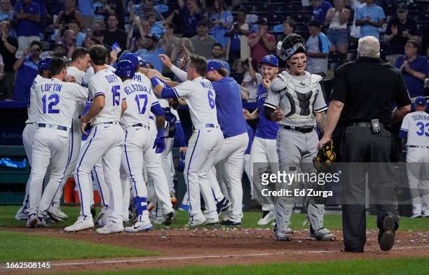 Korey Lee of the Chicago White Sox talks with plate umpire Bill Miller as the Kansas City Royals celebrate a 7-6 win at Kauffman Stadium on September...