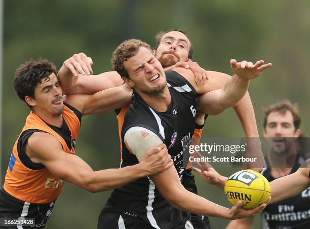 Jarrod Witts is tackled by Scott Pendlebury and Ben Hudson during a Collingwood AFL training session at the launch of the Collingwood Magpies new AFL...