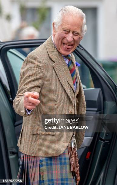 Britain's King Charles III laughs as he meets members of the public during a visit to the Discovery Centre and Auld School Close in Tomintoul,...