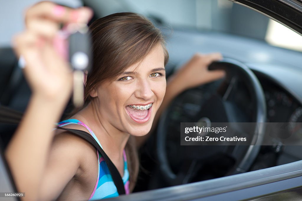 Teenage girl holding keys to new car