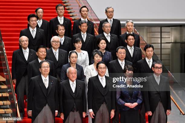 Japanese Prime Minister Fumio Kishida poses with new cabinet members at his official residence after new cabinet reshuffle, keeping in place some...