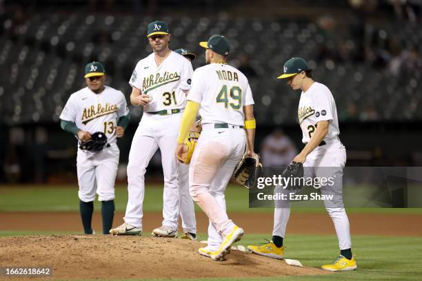 Teammates come out to speak to Zach Neal of the Oakland Athletics after he walked the bases loaded against the Toronto Blue Jays in the seventh...