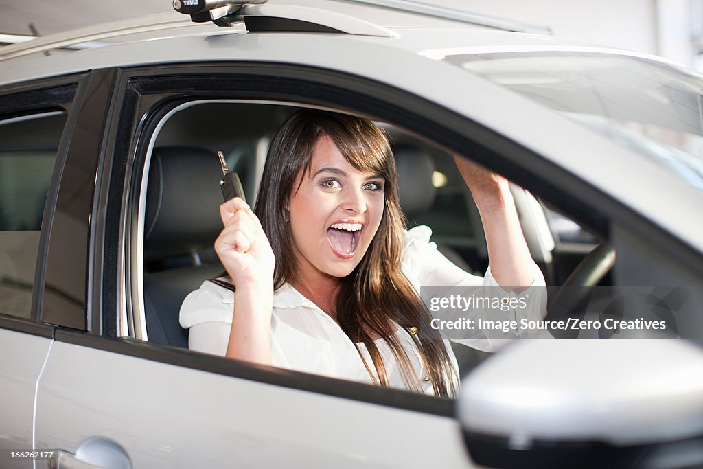 Cheering woman buying new car