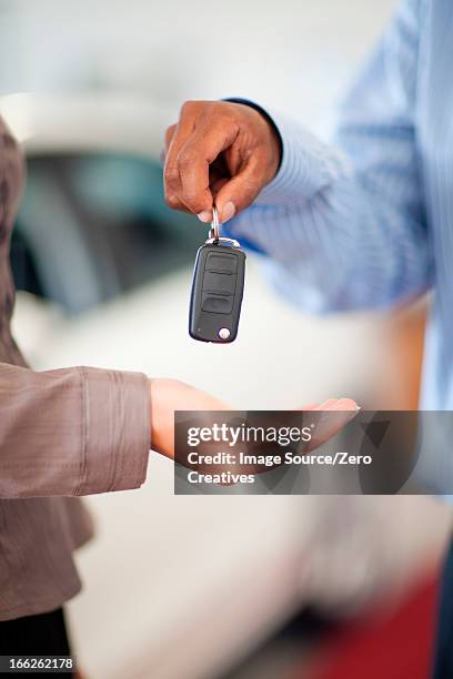 salesman handing woman new car keys - car keys hand stockfoto's en -beelden
