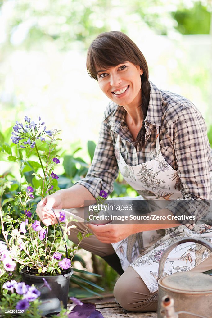 Woman examining plants in garden