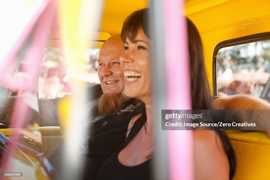 Couple laughing in colorful car