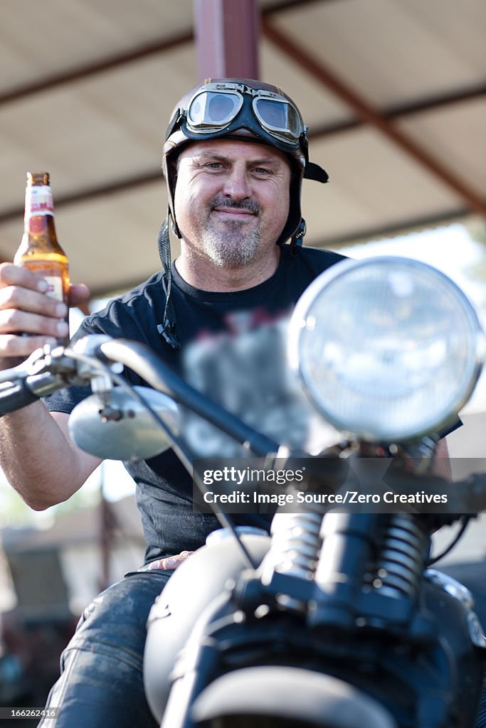 Man drinking beer on motorcycle