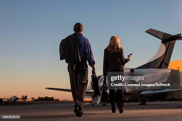 business people on airplane runway - answering stockfoto's en -beelden