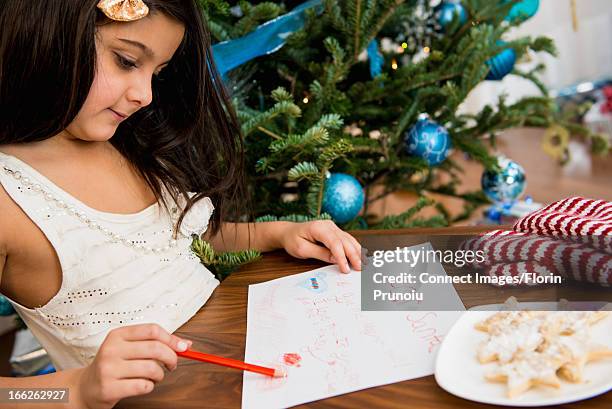 girl writing letter to santa at table - wunsch stock-fotos und bilder