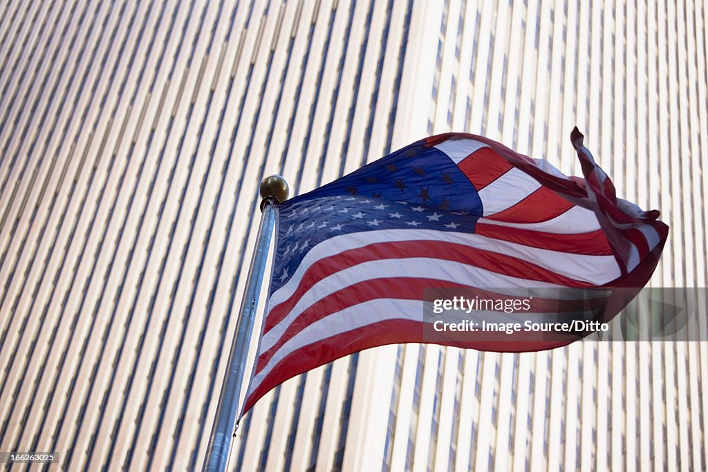 American flag flying by city skyscraper