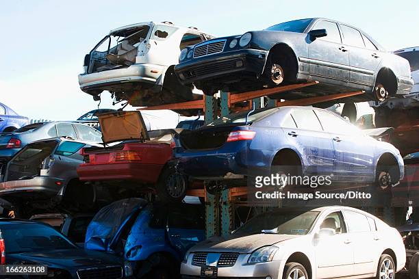 cars sitting in junkyard - autoschrottplatz stock-fotos und bilder