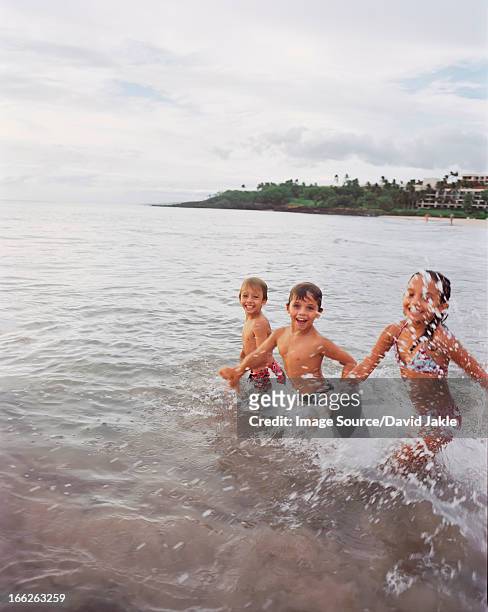children playing in waves on beach - hapuna beach 個照片及圖片檔