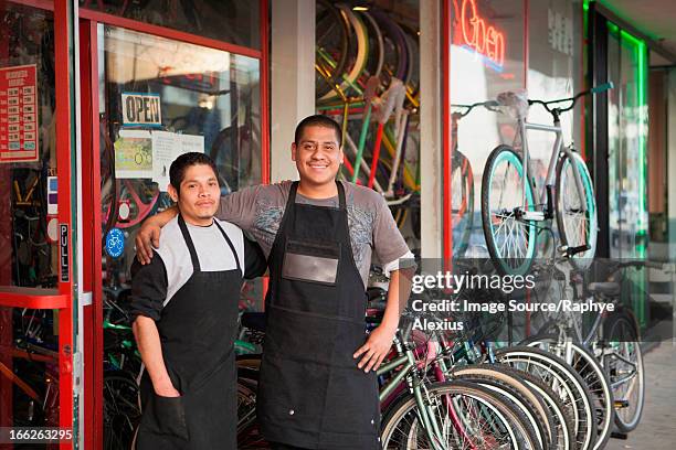 mechanics smiling outside bicycle shop - loja de bicicletas imagens e fotografias de stock