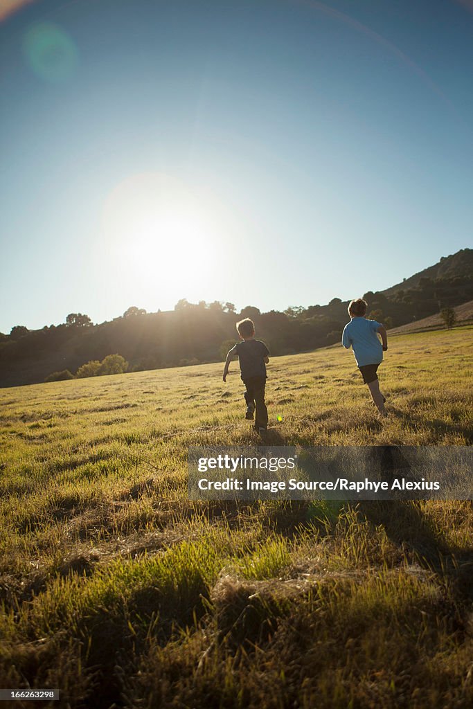 Boys running in grassy field