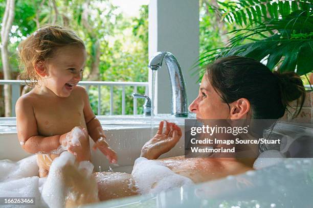 pregnant mother and toddler in bath - woman bath bubbles stock-fotos und bilder