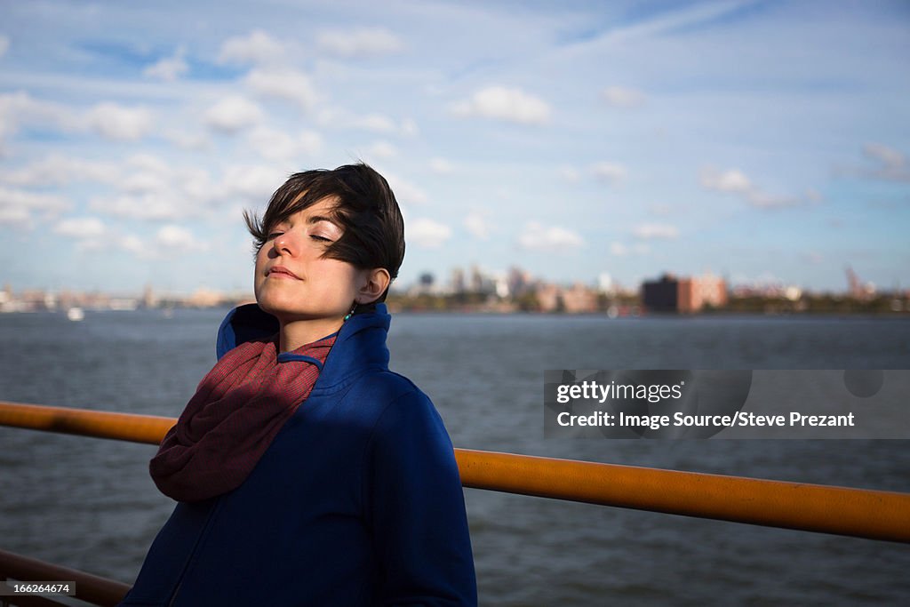 Woman on ferry in urban harbor