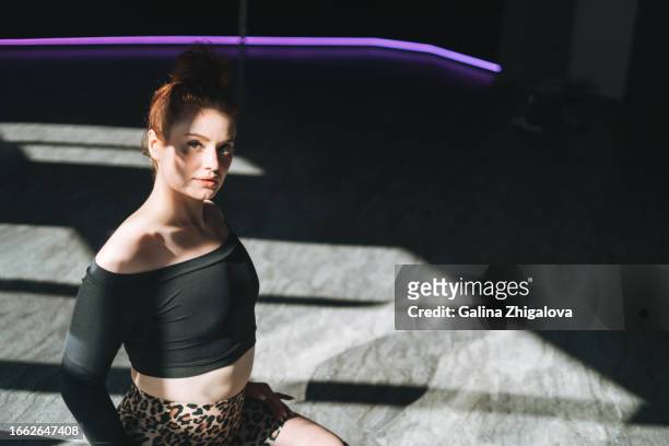 young red haired woman in sportswear dancing against mirror in the studio - pole dancing class stock pictures, royalty-free photos & images