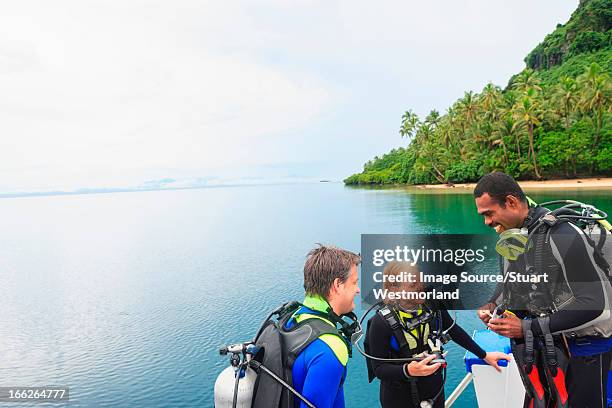 scuba divers talking on boat - fiji people stock pictures, royalty-free photos & images