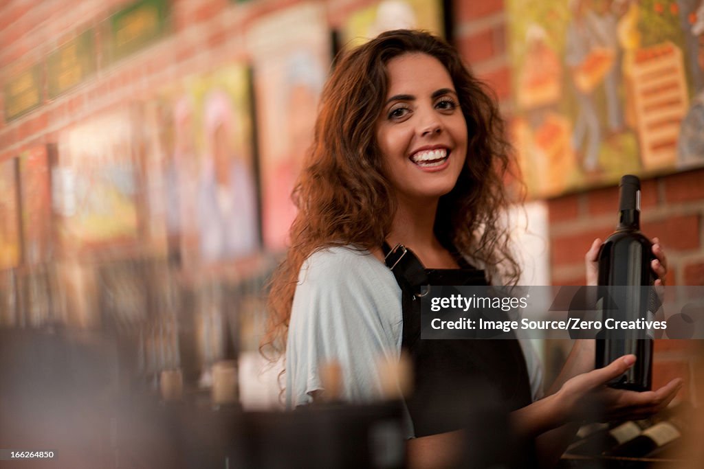 Server holding glass of wine in grocery