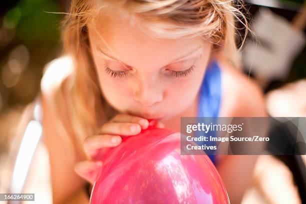 girl blowing up balloon at party - inflate stock-fotos und bilder