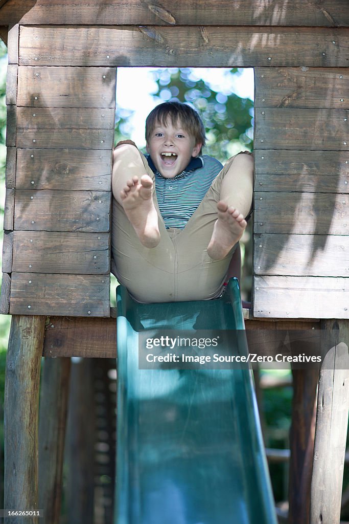 Boy playing on slide outdoors